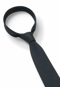 Cravate bleu marine avec de petits pois blancs, faite en tissu tissé. Présente un design classique avec une longueur et une largeur standard.