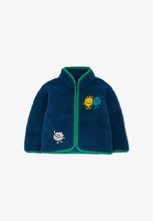 Blauwe fleecedeken met groene accenten, ritsluiting en geborduurde figuren: een zon, aarde en wolk. Zachte textuur en casual ontwerp.