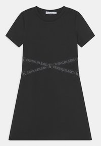Czarna sukienka t-shirt z krótkimi rękawami, z paskiem z logo CK przebiegającym przez talię. Wykonana z gładkiej tkaniny, o luźnym kroju.