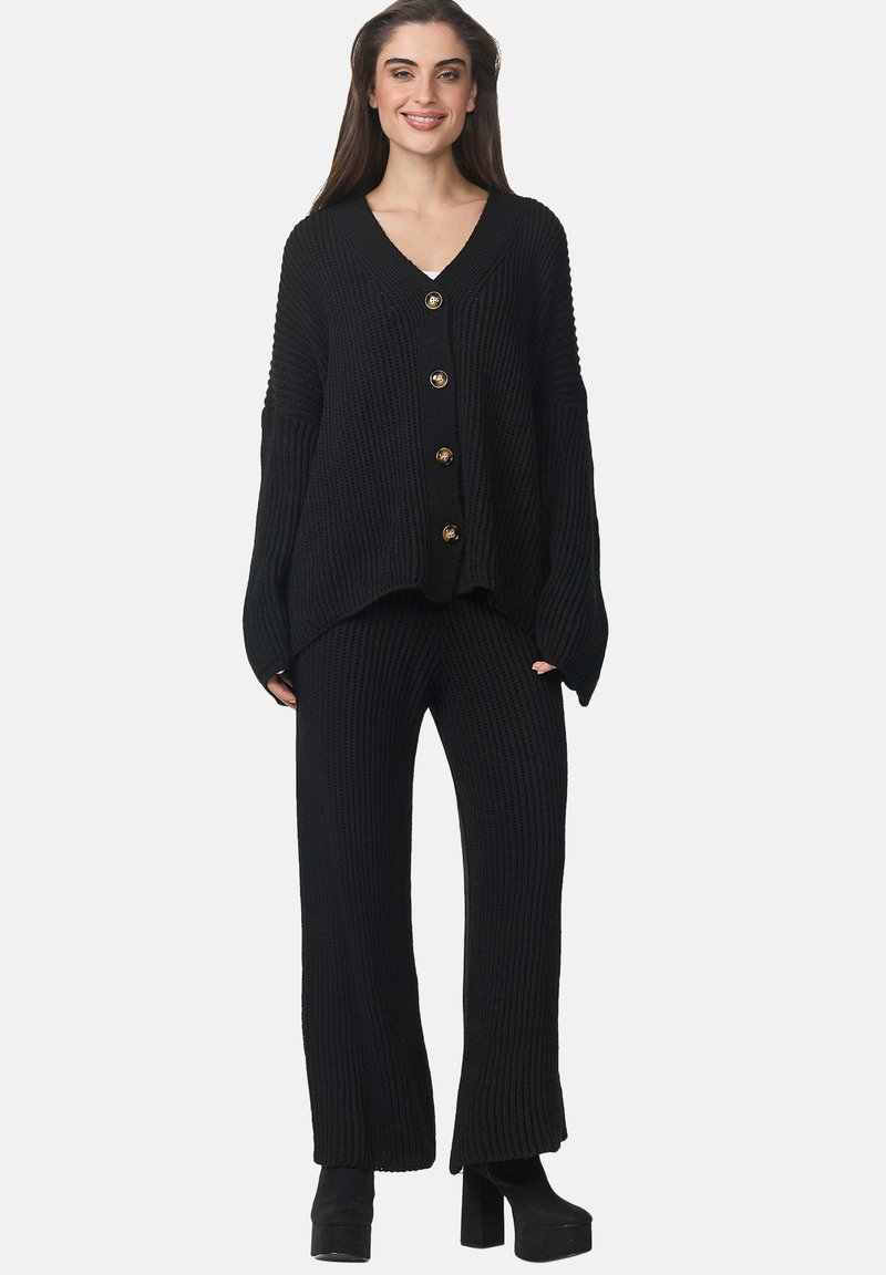 Zwarte gebreide loungewearset bestaande uit een V-hals cardigan met gouden knopen en wijde broek, die een geribbelde textuur en een relaxte pasvorm laat zien.