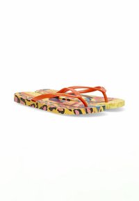 Chanclas con correas naranjas, base amarilla y un colorido patrón de leopardo con acentos en rosa y negro. Diseño plano y ligero.