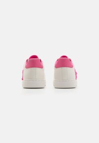Vita sneakers med rosa detaljer och texturerad design på sidorna. Slät läderöverdel, rundad tå och flat gummisula.