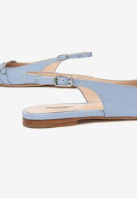 Chaussures slingback en cuir verni bleu clair avec une semelle plate, une sangle de cheville ajustable et un bout arrondi. Présente un petit nœud décoratif à l'avant.
