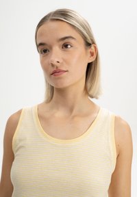 Lichtgele en witte gestreepte tanktop met een ronde halslijn en gele afwerkingen; gemaakt van katoen; aansluitend ontwerp.