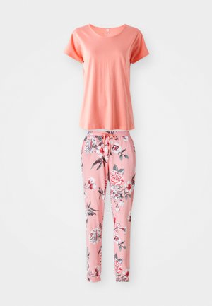 Korálové tričko s krátkym rukávom v kombinácii s ružovými nohavicami s kvetinovým vzorom, ktoré majú elastický pás a šnúrku na prispôsobenie.