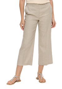 Beige, wijde pijpen broek van textuurstof met een gladde afwerking. Heeft een middelhoge taille en zijzakken. Gecombineerd met platte sandalen.