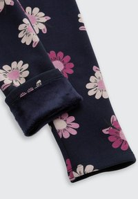 Marine bloemenleggings met roze en witte bloemenpatronen. Zachte stof met een pluche voering aan de manchetten voor extra comfort.