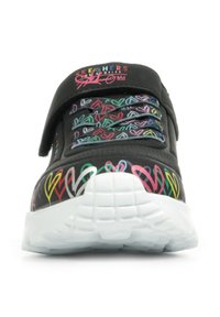 Schwarzer Sneaker mit bunten Herzmustern am Obermaterial, ausgestattet mit einem Klettverschluss und einer weißen, strukturierten Gummisohle.