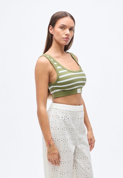 Πράσινο ριγέ crop top με ευρύ, στρογγυλεμένο ντεκολτέ και χονδρούς ιμάντες, κατασκευασμένο από ριμπ ύφασμα. Συνδυάζεται με άνετο λευκό παντελόνι eyelet.