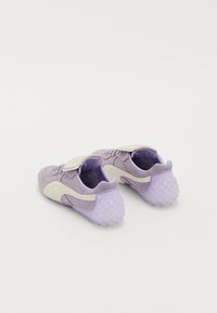 Purple suede sneakers with a light purple accent and textured rubber sole. Features a Velcro strap and a curved design.