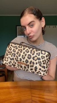Borsa cosmetica con stampa leopardata realizzata in tessuto testurizzato con zip dorata e dettagli in oro. Forma rettangolare, adatta per organizzare gli oggetti.