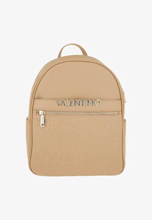Mochila beige Valentino con un bolsillo frontal con cremallera y un patrón de nombre de marca en relieve en la mitad inferior de la bolsa.