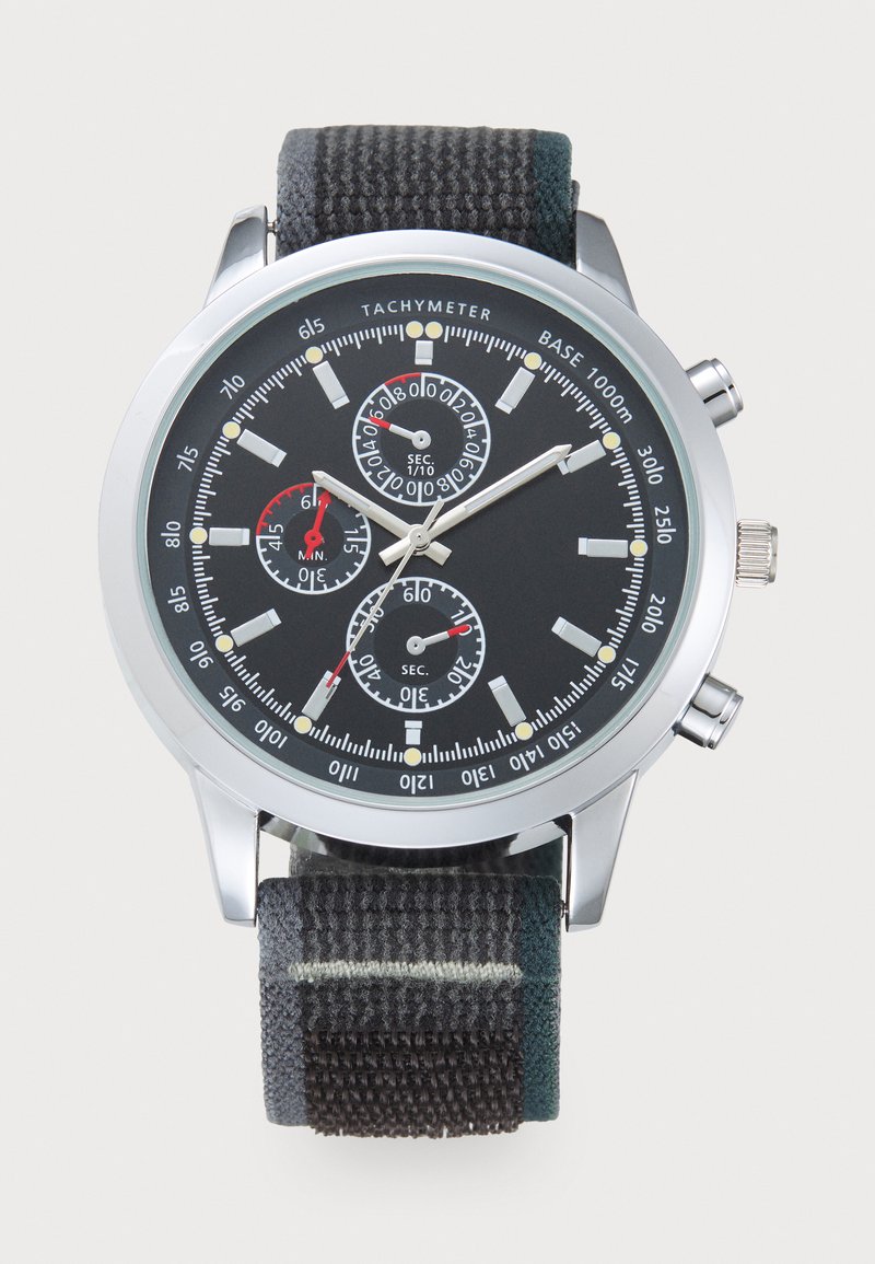 Orologio cronografo con quadrante nero, cassa argentata e cinturino in tessuto nero testurizzato. Presenta tre sottodial, scala tachimetrica e indicatori luminosi.
