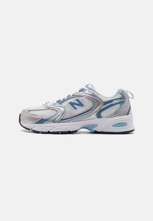 Biało-jasnoniebieski but do biegania New Balance z siateczkową cholewką i grubą amortyzowaną podeszwą, pokazany z profilu na jednolitym tle.