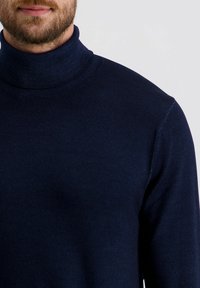 Marineblauwe turtleneck trui, gebreide stof, nauwsluitend ontwerp, ribbelkraag, gestructureerd oppervlak, minimalistische stijl, geen zichtbare logo's.