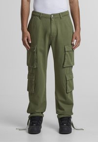 Roheline cargo püksid mitme külge taskuga, sirge lõikega, pehmest kangast, nupu sulgemise ja nööriga allääridega.