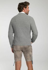 Grauer, gerippter Strickpullover mit Rundhalsausschnitt, langen Ärmeln und strukturiertem Finish, kombiniert mit beigen Shorts, die hellblaue Schnürsenkel haben.