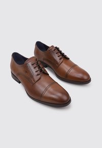 Zapatos de vestir de cuero marrón con punta redondeada, sistema de cordones cerrado y un diseño de costura sutil en la parte superior. Suela plana y duradera.