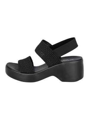 Sandalia plataforma negra con tiras tejidas, tira trasera elástica y suela gruesa, diseñada para uso casual.