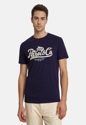 Camiseta azul marino de algodón, con un gran logo blanco "Petrol & Co" y diseño de bandera a cuadros. Mangas cortas y cuello redondo.