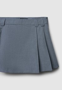 Gonna plissettata grigia realizzata in tessuto testurizzato, con una vita aderente e due pieghe frontali per un tocco di dettaglio in più. Bordo liscio e design su misura.
