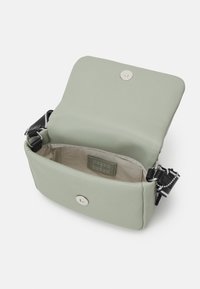 Borsa a tracolla strutturata in materiale testurizzato verde chiaro con chiusura a pressione magnetica. L'interno presenta una morbida fodera e l'etichetta del marchio.