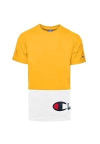 Žluté bavlněné tričko s bílou spodní částí, se znakem v námořnické modré a červené barvě. Krátké rukávy a kulatý výstřih.