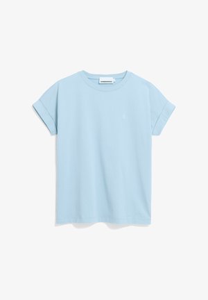 Camiseta de manga corta azul claro con puños remangados y pequeño logo blanco en el pecho izquierdo, presentada sobre un fondo blanco.