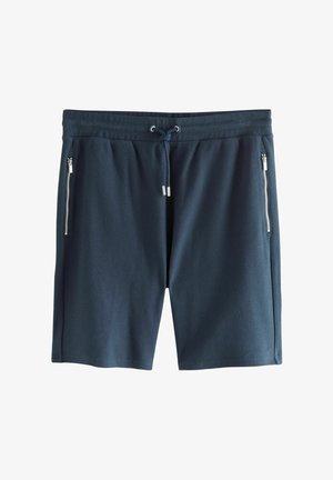 Tummansininen urheiluhousut, jotka on valmistettu teksturoidusta kankaasta, ja joissa on nauhavyötärö sekä kaksi vetoketjullista sivutaskua.