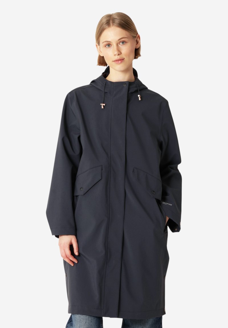 Granatowy wodoodporny płaszcz z kapturem, z przednimi kieszeniami, z zapięciem na napy i luźnym krojem. Gładka faktura z minimalnymi detalami.
