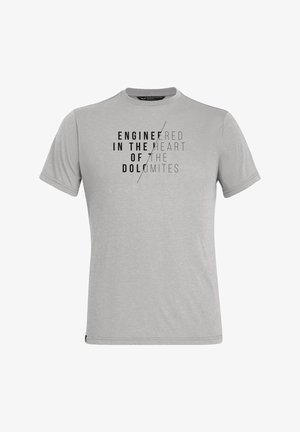 T-shirt gris clair à manches courtes avec texte noir « Engineered in the heart of the Dolomites » divisé par une ligne diagonale sur la poitrine.