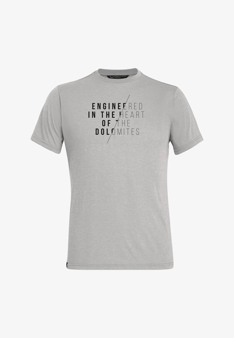 T-shirt gris clair à manches courtes avec texte noir « Engineered in the heart of the Dolomites » divisé par une ligne diagonale sur la poitrine.