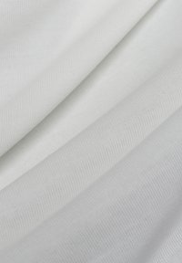 Katoenen stof met een gladde textuur, die subtiele weefpatronen vertoont in verschillende tinten wit en lichtgrijs, keurig opgevouwen.