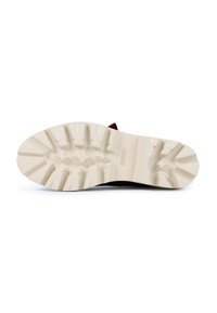 Suela de bota de goma marrón con un patrón de relieve texturizado, una mediasuela blanca y un logo en relieve. Duradera y diseñada para ofrecer tracción.