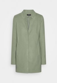 Cappotto in lana verde chiaro a maniche lunghe con colletto rialzato, zip frontale nascosta e due tasche laterali su sfondo bianco.
