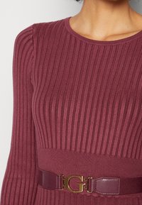 Haut en maille bordeaux côtelé doté d'une large ceinture texturée avec un détail boucle logo 'G' dorée.