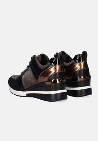 Zapatillas deportivas negras y bronce con un diseño elegante, que presentan un tejido texturizado, acentos brillantes, un tacón cuña y una suela blanca.