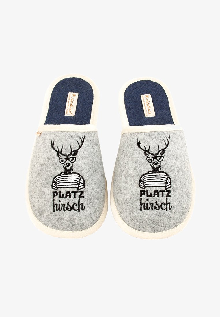 Graue Slip-On Hausschuhe mit marineblauen Innensohlen, die einen Hirsch mit Brille und gestreiftem Shirt zeigen, mit dem eingestickten Text "PLATZ hirsch".