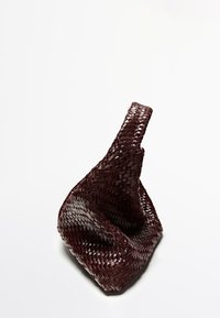 Vävd mörk bordeaux handväska med en unik, skulptural form och ett enda handtag. Har tajt, texturerad flätning.