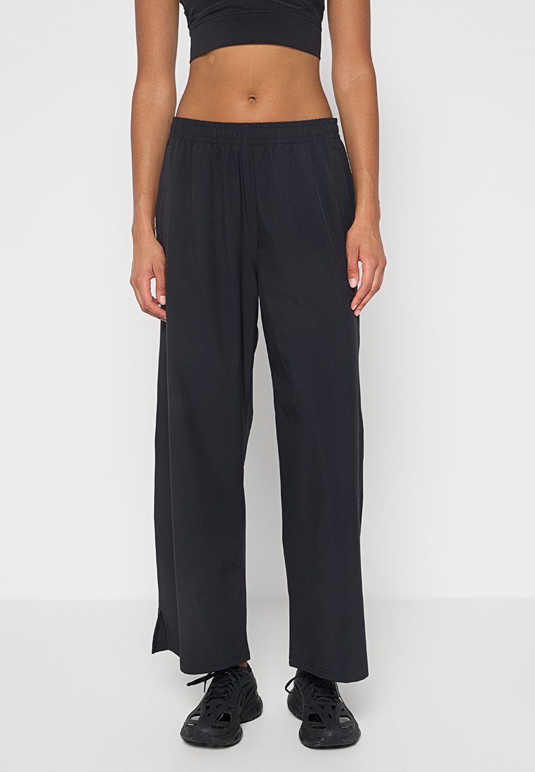 Pantalons noirs à jambes larges en tissu léger avec une taille élastique, présentant une texture lisse et sans motifs ni accessoires visibles.