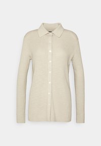 Beige långärmad cardigan med ribbad textur, knäppning fram, spetsig krage och förlängda ärmar. Mjuk stickad material.