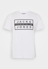 White cotton t-shirt with short sleeves, featuring a black rectangular graphic that includes "JACK & JONES" and additional text.