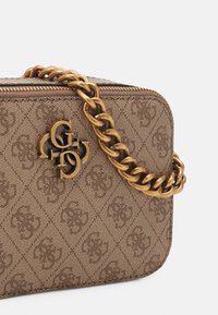 Brun mønstret rektangulær håndtaske med guldfarvet kædetræk og guld brandlogo på fronten samt lynlås lukning øverst.