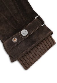 Brązowa skórzana rękawiczka z ribbanym dzianinowym mankietem, srebrnym metalowym guzikiem oraz subtelnymi przeszyciami na zewnętrznej powierzchni.