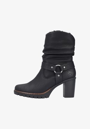 Bottine en cuir noir avec un design drapé, bout rond, sangle décorative avec matériel en métal et talon épais avec semelle texturée.