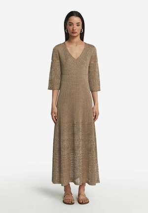 Robe maxi en tricot beige avec un décolleté en V, des manches trois-quarts et une texture à motifs, comportant des fils métalliques subtils et un ourlet évasé.