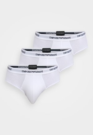 Culottes blanches en coton avec une coupe ajustée et une ceinture élastique portant le logo "Emporio Armani". Trois paires sont affichées.