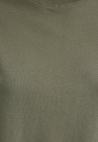 Olive green, ribbed t-shirt made from soft material, featuring a crew neckline and seamless stitching for a smooth finish.