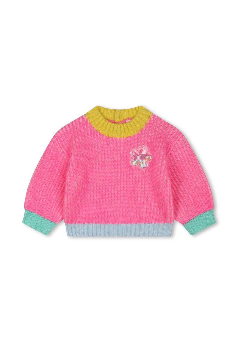 Pull en tricot de couleur rose vif avec un col rond jaune. Il présente des poignets et un ourlet vert menthe, ainsi qu'une patch décorative en forme de fleur à l'avant.