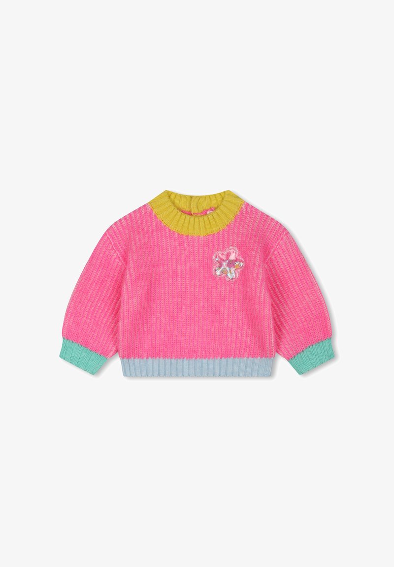 Pull en tricot de couleur rose vif avec un col rond jaune. Il présente des poignets et un ourlet vert menthe, ainsi qu'une patch décorative en forme de fleur à l'avant.